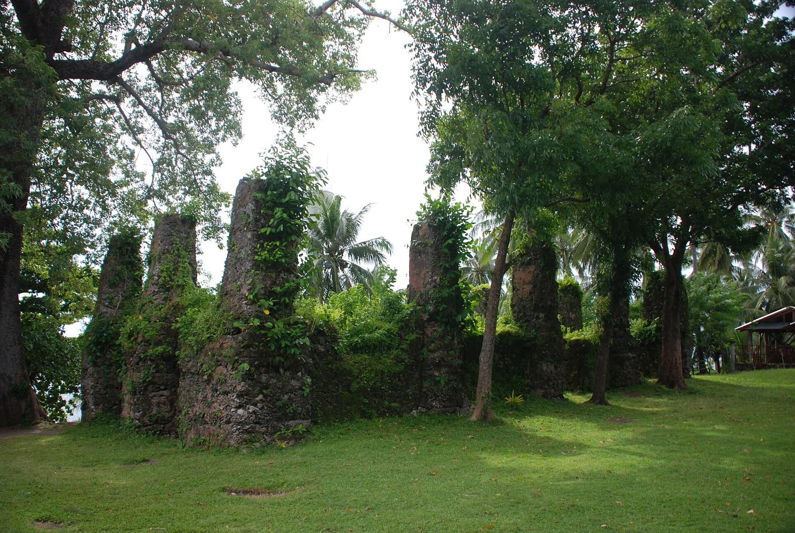 Moss-covered stone walls of the old church ruins in Bonbon, Catarman, shaded by trees