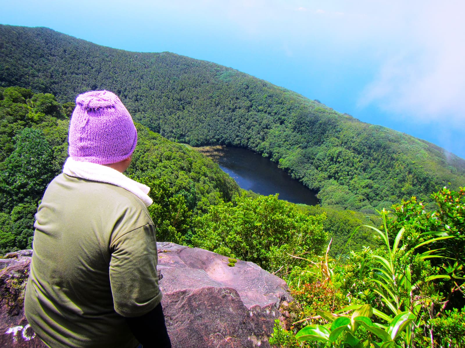 A hiker looking into a forest-ringed crater high on Mount Hibok-Hibok