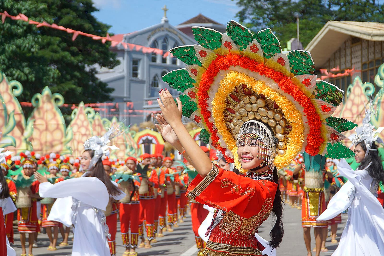A dancer in a bright costume performing at the Lanzones Festival in Mambajao