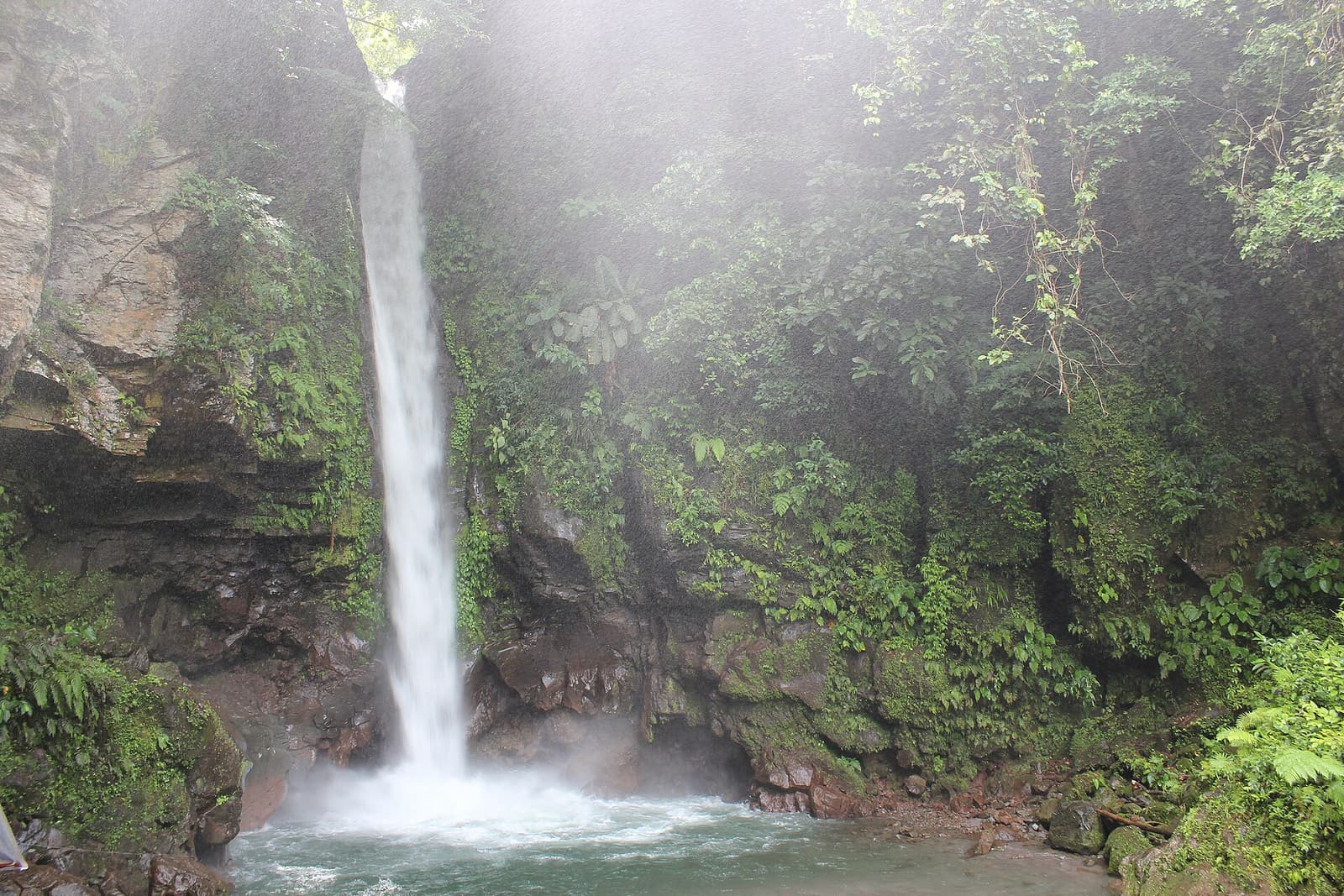 Tuasan Falls pouring into a rocky pool surrounded by forest in Catarman, Camiguin